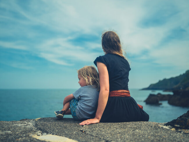 Mother and child sat on the coastline
